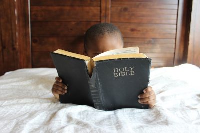 bimbo africano che legge una Bibbia